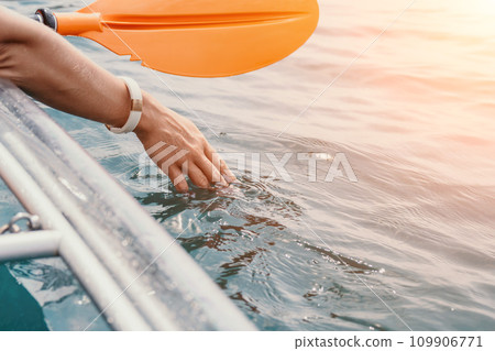 Woman in kayak back view. Happy young woman with long hair floating in transparent kayak on the crystal clear sea. Summer holiday vacation and cheerful female people relaxing having fun on the boat Woman in kayak back view. Happy young woman with long hair floating in transparent kayak on the crystal clear sea. Summer holiday vacation and cheerful female people relaxing having fun on the boat 109906771