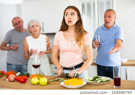 Husband and parents scold young wife in kitchen Husband and parents scold young wife in kitchen 109906784