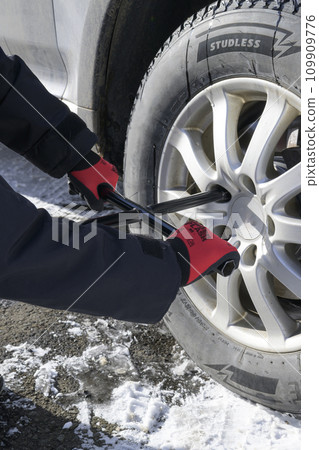 A man retightening a tire nut 109909776