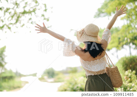 Portrait of asian young woman traveler with weaving hat and basket and a camera on green public park nature background. Journey trip lifestyle, world travel explorer or Asia summer tourism concept. Portrait of asian young woman traveler with weaving hat and basket and a camera on green public park nature background. Journey trip lifestyle, world travel explorer or Asia summer tourism concept. 109911485