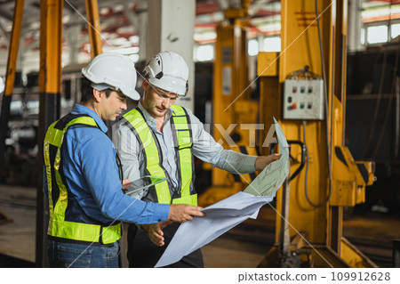 Engineer team smart young skill worker consulting supervisor working together with design floor plan in locomotive train depot workshop 109912628