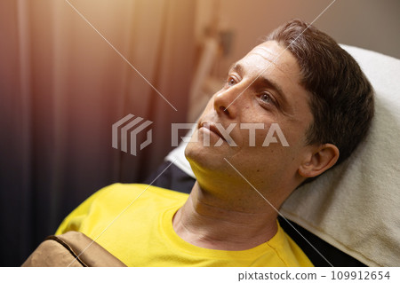 closeup caucasian adult male face head model handsome laying on cosmetic clinic bed relax smile waiting for facial treatment procedure closeup caucasian adult male face head model handsome laying on cosmetic clinic bed relax smile waiting for facial treatment procedure 109912654