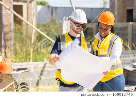 Professional construction workers engineer man working with women team. Real estate house project builder teamwork. Smart architect people standing work in construction site. 109912749
