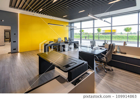 Modern office space with tables and chairs, computers and office supplies with no employees Modern office space with tables and chairs, computers and office supplies with no employees 109914863