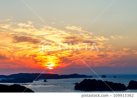 Beautiful sunset - orange sun visible between the clouds 109915362