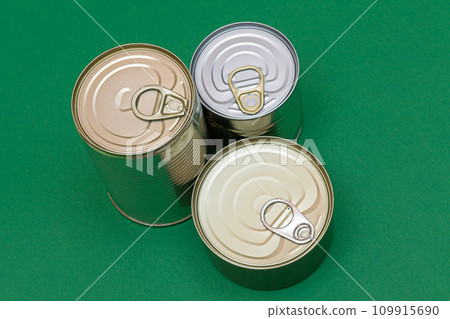 Unopened Tin Cans with Blank Edges on Green Background Unopened Tin Cans with Blank Edges on Green Background 109915690