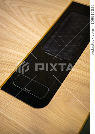 Mobile phone with wireless charger on table. Modern workplace accessory 109915835
