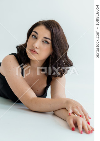 Portrait of a young beautiful girl in a black dress on a white background Portrait of a young beautiful girl in a black dress on a white background 109916054