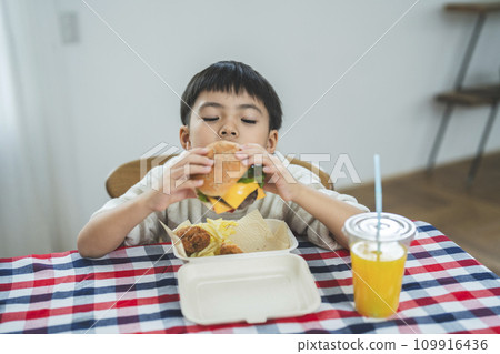 boy eating cheeseburger boy eating cheeseburger 109916436