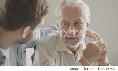 Helpful adult son supporting senior father upset with a problem, family care 109916709