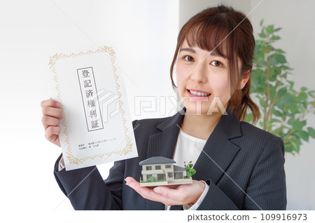 Woman with real estate deed and house model Woman with real estate deed and house model 109916973
