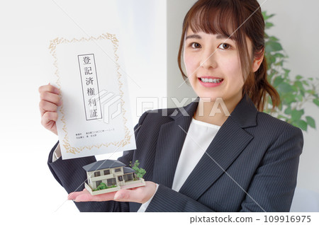 Woman with real estate deed and house model Woman with real estate deed and house model 109916975
