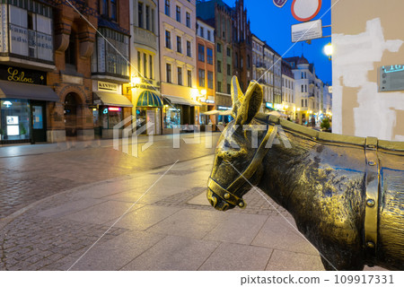 2022-07-04. Old bronze sculpture of a donkey on the street in the historical district of Torun. 109917331