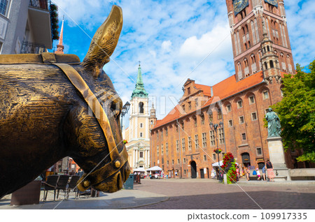 2022-07-06. Old bronze sculpture of a donkey on the street in the historical district of Torun. 109917335