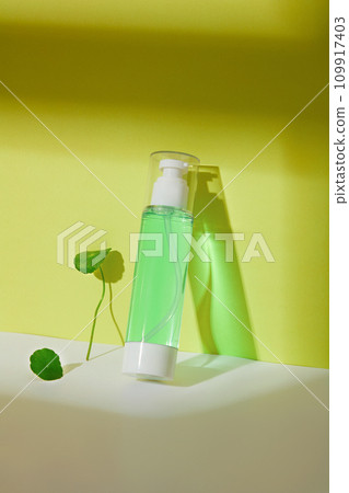 Close-up of a toner bottle containing light green liquid with pennywort extract. The concept of homemade cosmetics from natural ingredients - safe for the skin. 109917403