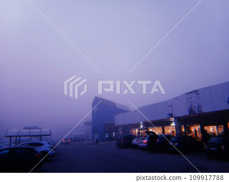 Shopping center at dusk with fog near Milan, Italy, in 2022. Shopping center at dusk with fog near Milan, Italy, in 2022. 109917788