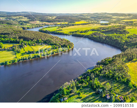 Curves of Vltava river in green landscape on sunny summer day. Aerial drone view. 109918538