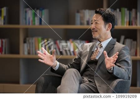 穿著西裝,在訪談中用手勢解釋的商人,如總統、經理、教授等。 穿著西裝,在訪談中用手勢解釋的商人,如總統、經理、教授等。 109919209