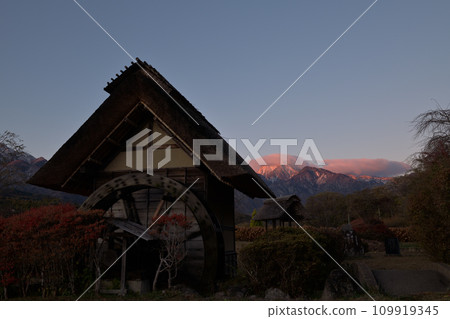 The watermill in Suisha-no-Sato Park and Mt. Kaikomagatake, which glows red in the morning sun The watermill in Suisha-no-Sato Park and Mt. Kaikomagatake, which glows red in the morning sun 109919345