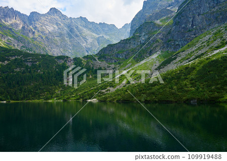 Amazing view on mountains range near beautiful lake at summer day. Tatra National Park in Poland. Panoramic view on Morskie Oko or Sea Eye lake in Five lakes valley 109919488