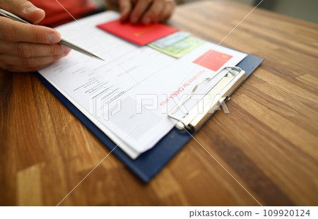 Male hand hold silver pen with passport Male hand hold silver pen with passport 109920124