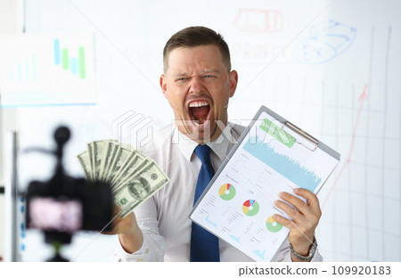 Angry businness vlogger hold in hands dollars Angry businness vlogger hold in hands dollars 109920183