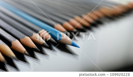 Blue pencil spy between black pencils 109920228