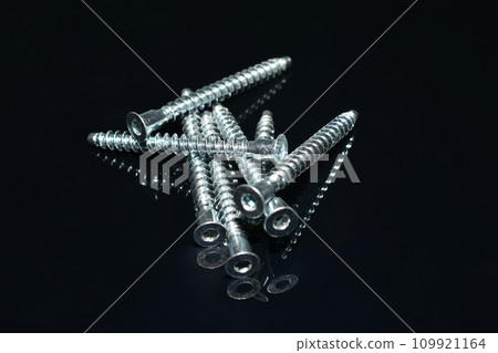 Furniture confirmations made of stainless steel on a dark background. Furniture confirmations made of stainless steel on a dark background. 109921164