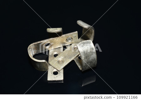 Furniture hooks made of brass on a dark background. Furniture hooks made of brass on a dark background. 109921166