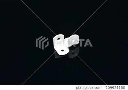 Furniture hooks made of white steel on a dark background. Furniture hooks made of white steel on a dark background. 109921168