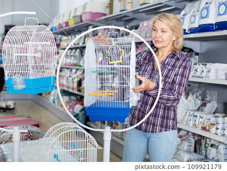 Woman buying cage for bird in shop Woman buying cage for bird in shop 109921179