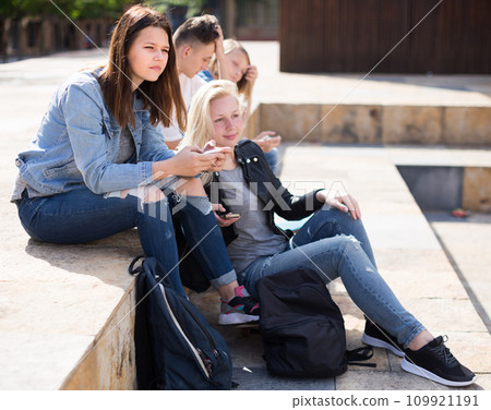 Teenagers communicate with each other in the schoolyard Teenagers communicate with each other in the schoolyard 109921191