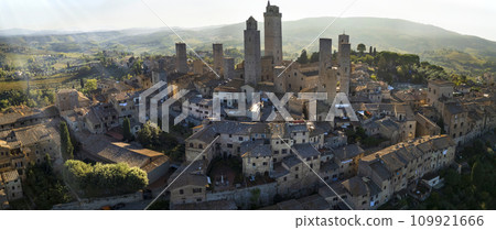 San Gimignano - one of the most beautiful medieval towns in Tuscany, Italy. aerial drone panoramic view with green agricultures filelds and Unesco heritage site. San Gimignano - one of the most beautiful medieval towns in Tuscany, Italy. aerial drone panoramic view with green agricultures filelds and Unesco heritage site. 109921666