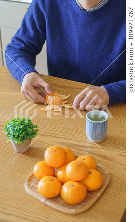 Man peeling mandarin oranges, mandarin oranges and green tea 109921767