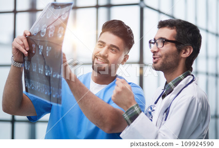 Two caucasian doctors view mri picture and discussing about it. Close up. 109924590