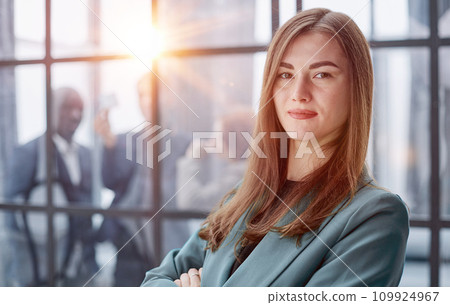 Portrait of a confident young businesswoman standing with her arms crossed in an office 109924967