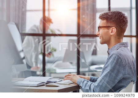 side view of handsome young businessman looking at computer 109924970