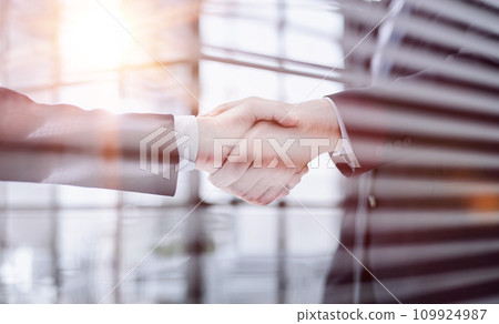 executives shaking hands in front of their manager and a colleague executives shaking hands in front of their manager and a colleague 109924987