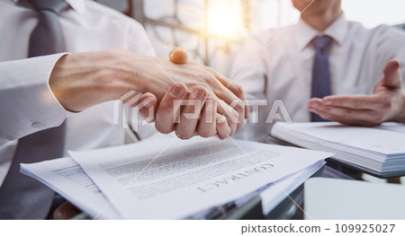 Close up businessman shaking hands with caucasian client. Close up businessman shaking hands with caucasian client. 109925027