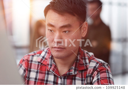Modern office businessman in casual clothes working on a computer. 109925148