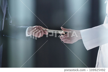 Man offering batch of hundred dollar bills. Hands close up. 109925492