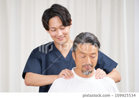 A young chiropractor performing a treatment on a man 109925534