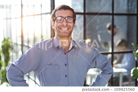 Young businessman in casual clothes stands with his hands on his waist Young businessman in casual clothes stands with his hands on his waist 109925560