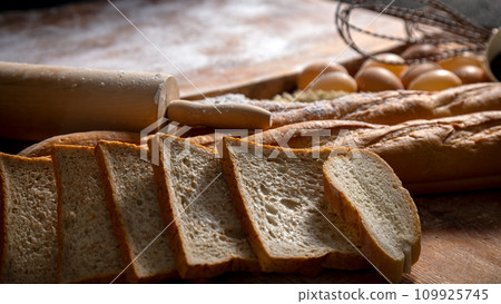 A Bakery Delight ingredient with sliced bread and loaf with wooden knead, egg A Bakery Delight ingredient with sliced bread and loaf with wooden knead, egg 109925745