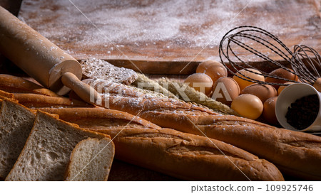 A Bakery Delight ingredient with sliced bread and loaf with wooden knead, egg 109925746