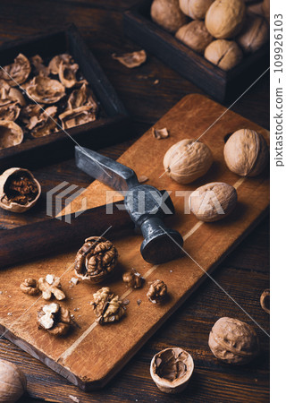 Cracked walnuts and hammer Cracked walnuts and hammer 109926103
