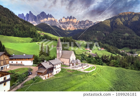 Stunning Alpine scenery of breathtaking Dolomites rocks mountains in Italian Alps, South Tyrol, Italy. Aerial view of Val di Funes and village Santa Maddalena, Valley Isarco Stunning Alpine scenery of breathtaking Dolomites rocks mountains in Italian Alps, South Tyrol, Italy. Aerial view of Val di Funes and village Santa Maddalena, Valley Isarco 109926181