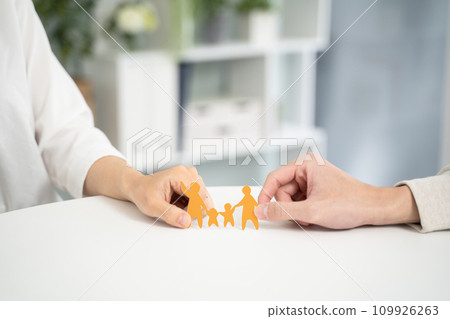 Hands of a couple working together and holding a paper cutout of their family Hands of a couple working together and holding a paper cutout of their family 109926263