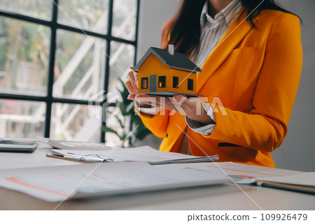 real estate agent Delivering sample homes to customers, mortgage loan contracts. Make a contract for hire purchase and sale of a house. and home insurance contracts, home mortgage loan concepts real estate agent Delivering sample homes to customers, mortgage loan contracts. Make a contract for hire purchase and sale of a house. and home insurance contracts, home mortgage loan concepts 109926479