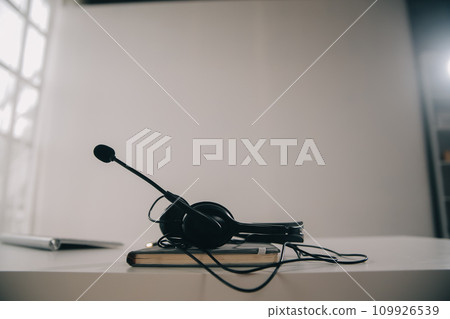 Communication support, call center and customer service help desk. VOIP headset on telephone keyboard. 109926539
